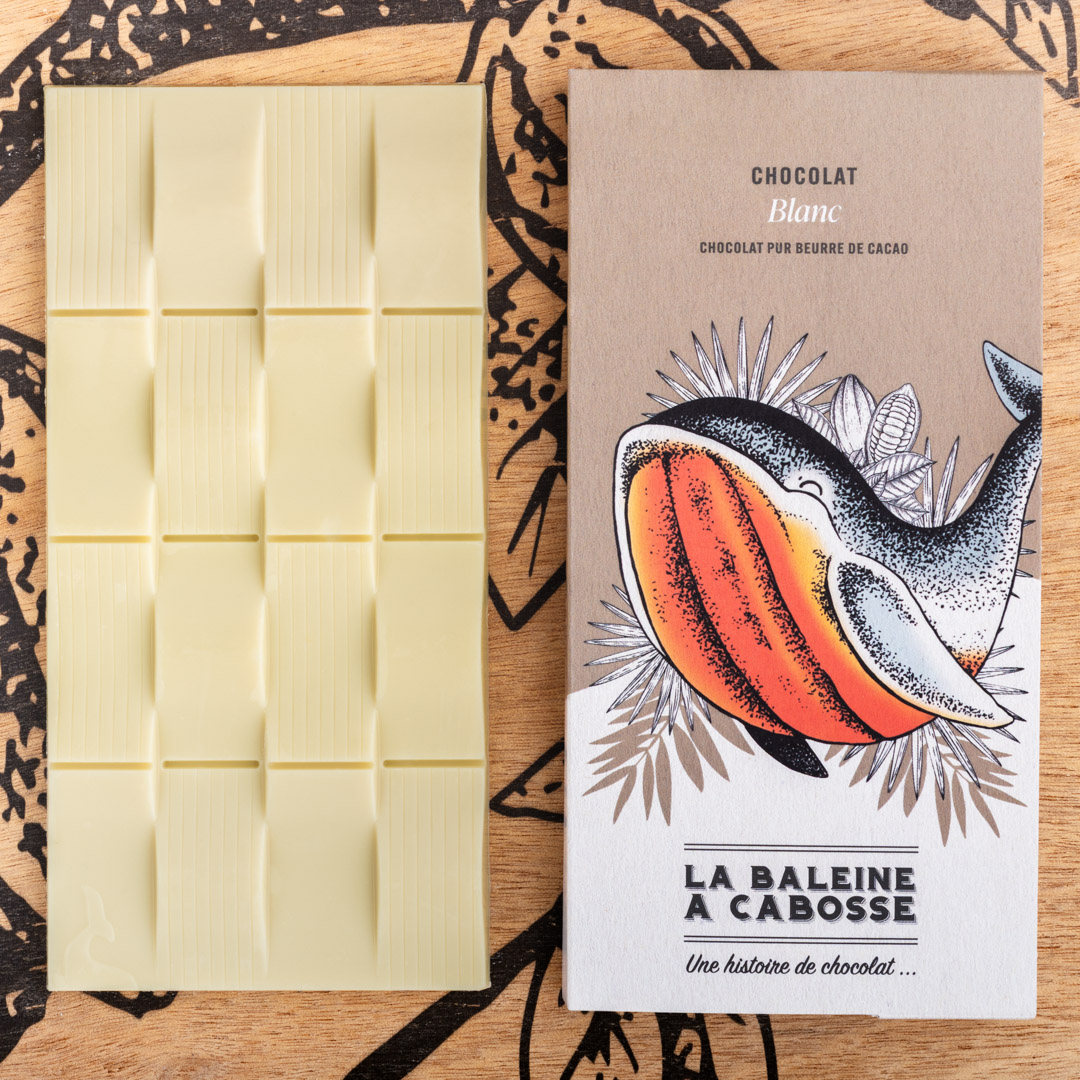 Tablette Chocolat blanc 1 Tablette Chocolat blanc de La Baleine à Cabosse dans son emballage, posée à côté d'une tablette de chocolat blanc sans emballage